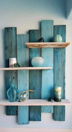 some shelves made out of wooden planks with vases and candles on top of them