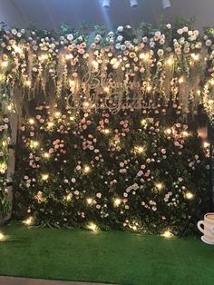 an artificial wall with flowers and lights on it