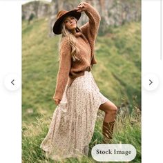 a woman in a long dress and cowboy hat posing for the camera with her hand on her hip