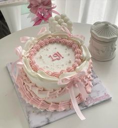 a birthday cake decorated with pink and white icing