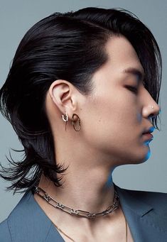 a woman with black hair and piercings on her ear next to an image of a man in a suit