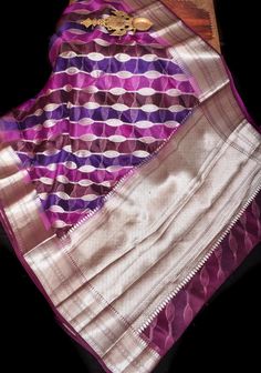 Discover the lavishness of the rganza Silk Saree, skillfully designed to highlight ZLeheria ari diagonal lines and Floral Motifs. With tones of Purple, Pink, and Plum, this saree boasts precision weaving and a Zari Border for a touch of grandeur. SILK MARK CERTIFIED This saree is ready to wear with fall and pico done. Handmade silk tassels adorn the pallu and add more grace to it. An unstitched blouse fabric is included. *Note: There may be minor variations in the shade, the texture of the produ Silk Tassels, Organza Silk Saree, Diagonal Lines, Diagonal Line, Floral Motifs, Blouse Fabric, Handmade Products, Salwar Kameez, Floral Motif