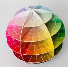 three different colors of paper stacked on top of each other in the shape of an umbrella