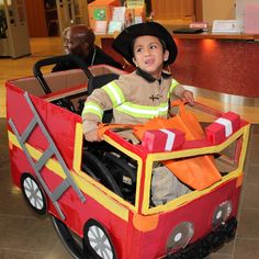 a young boy in a fire truck costume