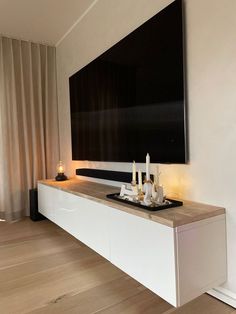 a flat screen tv mounted to the side of a wall next to a wooden floor