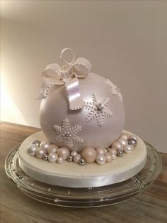 a white christmas ornament sitting on top of a glass plate covered in pearls