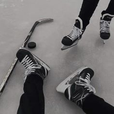 two people are skating on an ice rink with their feet in the air and one person is wearing black and white sneakers