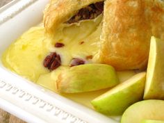 an apple pie with pecans and apples on the side in a white dish, ready to be eaten