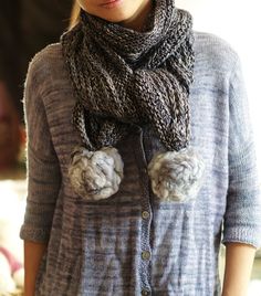 a woman wearing a gray sweater and scarf