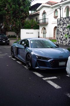 a blue sports car parked in front of a building on the side of the road