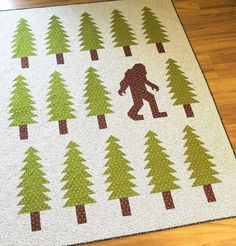 a quilted rug with a bigfoot and trees on it in the shape of a bear