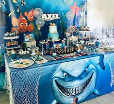 an under the sea themed birthday party with shark cake and cupcakes on a table