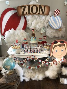 a table topped with cake and cupcakes on top of a cloud covered floor