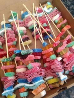 an open box filled with marshmallows and lollipops on sticks