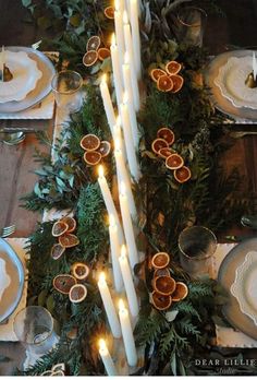 the table is set with candles and orange slices