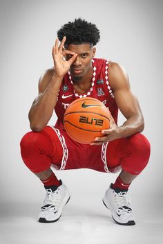 a man holding a basketball in his hands and posing for the camera with one hand on his face