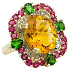 Ring Size: 6.5 This stunning ring showcases a vibrant blend of gemstones set in 14 karat yellow gold, creating a captivating and colorful design. At its center is a large oval citrine, radiating warmth and brilliance. Surrounding the citrine is a halo of round rubies, adding a rich contrast of color and depth to the piece. Accentuating the design are pear-shaped peridot stones, which enhance the ring's overall aesthetic with their fresh green hue. The combination of citrine, rubies, and peridot creates a dynamic and eye-catching composition, making this ring a unique and stylish accessory for any occasion. With its bright colors and elegant design, it's sure to be a standout addition to any fine jewelry collection. This piece is in very good estate condition and has been professionally cle Glamour Jewelry, Red Topaz, Peridot Color, Citrine Jewelry, Ring Ruby, Gift Suggestions, Sterling Silver Bangle Bracelets, Gold Gemstone Ring, Solid Gold Ring