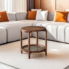 a living room with white couches and orange pillows on the walls, along with a coffee table