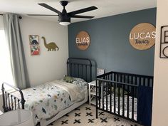 a baby's room with a crib and dinosaur wall decals