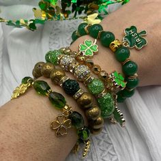 "These St. Patrick's Day green and golden tone beaded stretchy bracelets are handcrafted personally for me, Derlis. You can pick your size bracelet.  Choose your favorite color stone with assorted one-sided golden tone charm. You can get the full set of 5 bracelets, or separately and mix and match to create your own stack. Perfect for both kids and adults alike to celebrate your Irish heritage and pride. But many people (not just the Irish) can get into the spirit of this day by dressing in green with this gorgeous bracelets. It is very important that you measure your wrist before placing your order to find your correct size bracelet. You can use a flexible tape measure, or a piece of paper, or shoe string, wrap it around your wrist where you would normally put your watch and then use a ru Beaded Bracelets Green, Bracelets Green, Gold Stretch Bracelet, Irish Clover, Irish Heritage, Square Bead, Stretchy Bracelets, Holiday Jewelry, Color Stone