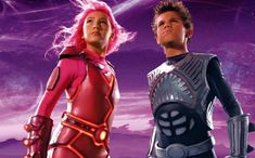 two children dressed in futuristic garb standing next to each other on a purple background