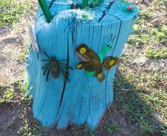 a tree stump with some bugs on it and flowers in the center, painted blue