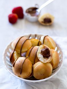 a white bowl filled with donuts covered in chocolate