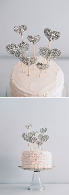 the cake is decorated with silver sparkles and hearts on it's top, while the rest of the cake has white frosting