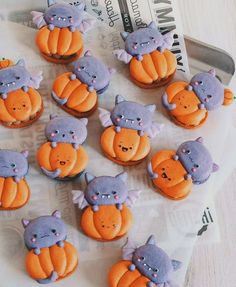 there are many cupcakes decorated to look like cats and pumpkins on the table