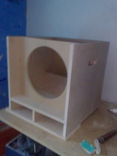 a wooden box sitting on top of a table next to paint rollers and a blue wall