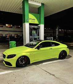 a bright yellow car is parked in front of a gas station