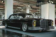 an old black car parked in a garage