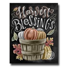 a chalkboard sign that says harvest blessing with pumpkins and acorns in a basket