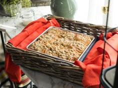 a basket filled with food sitting on top of a table next to a glass vase