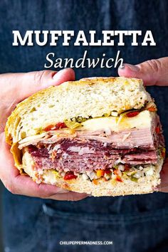 a person holding a sandwich in their hands with the words muffaletta sandwich on it