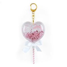 a heart shaped keychain with pink and white confetti in the shape of a cat