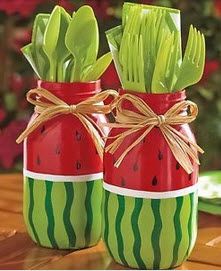 two mason jars filled with green leaves and red watermelon slices, tied with twine