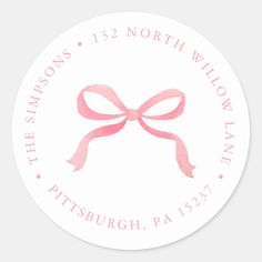 a round sticker with a pink ribbon on the bottom and words that say,