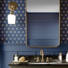 a bathroom with blue and gold wallpaper, two sinks and a large mirror on the wall