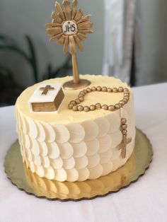 a cake with a cross on top and a rosary hanging from it's side