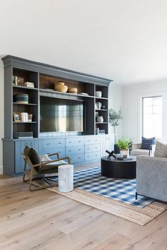 a living room filled with furniture and a flat screen tv on top of a wooden entertainment center