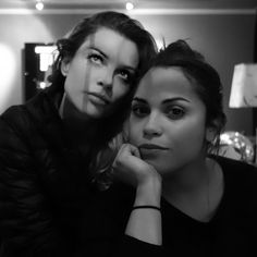 two women are posing for the camera in black and white