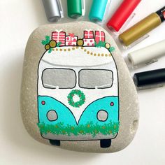 a rock painted with an image of a camper van on it and markers next to it