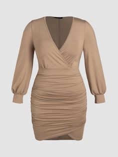 a woman wearing a tan dress with long sleeves Solid Color Ruched Dress With Surplice Neckline, Stretch Ruched Dress With Surplice Neckline, Ruched Stretch Dress With Surplice Neckline, Fall Long Sleeve Ruched V-neck Dress, Beige Long Sleeve Ruched Dress, Ruched V-neck Dress For Fall, Fall Ruched V-neck Dress, Fall V-neck Ruched Mini Dress, Fall V-neck Ruched Dresses