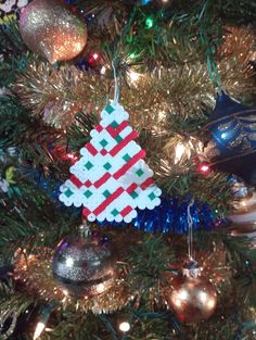 an ornament hanging from the top of a christmas tree