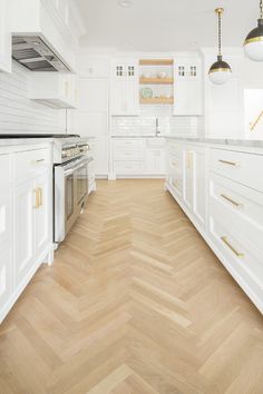 an empty kitchen with white cabinets and wood flooring on the walls is pictured in this image