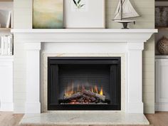 a fire place in a living room with a sailboat on the wall behind it