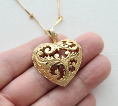 "Vintage ornate cutout filigree goldtone doned metal heart on long vintage goldtone bar chain. the herat pendant is approximately 1-1/2\" tall including the bail. the chain is 30\". it is in good condition consistent with age and use." Valentine's Day Gold Necklace With Intricate Design, Ornate Gold Heart Pendant Necklace, Ornate Gold Heart Pendant Jewelry, Gold Filigree Heart Necklace, Ornate Gold Necklaces For Valentine's Day, Gold Heart Filigree Necklace, Ornate Gold Jewelry With Heart Charm, Ornate Gold Jewelry For Valentine's Day, Ornate Gold Necklace For Valentine's Day