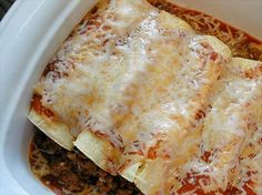 a casserole dish with meat, cheese and tomato sauce in a white bowl