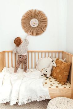 a little boy standing on top of a wooden crib